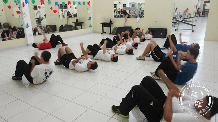 Foto sede 2013 grande turma de alunos fazendo exercícios deitados no chão